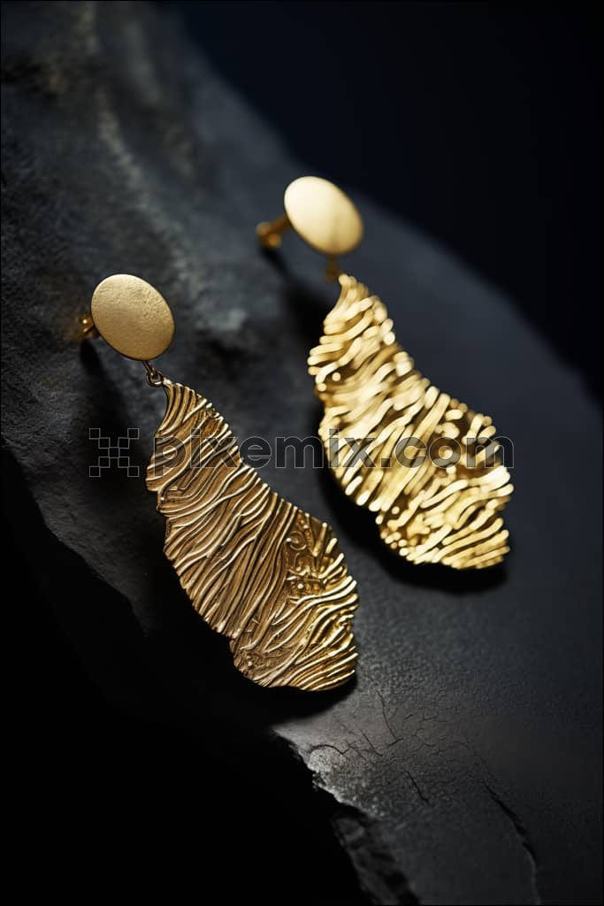 Bold statement piece, gold jewellery on a black matt stone image.