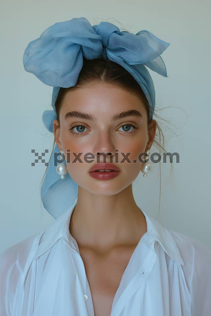 A young woman in a blue bow hairband and beautiful soft makeup.