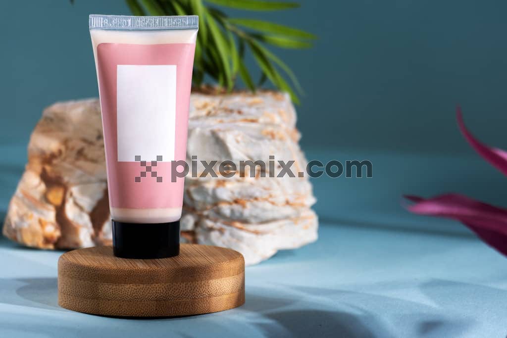 The image shows a sleek skin care tube sits on a round wooden stand, exuding elegance.