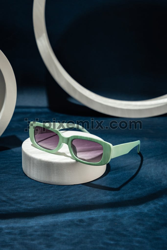 The image shows  a pair of sunglasses in a soft pastel green color.